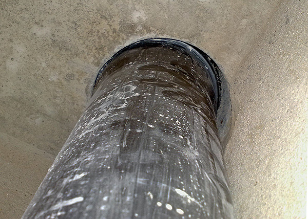 La foto mostra un esempio dello spazio tra il tubo fognario e le pareti del foro nel soffitto della toilette.